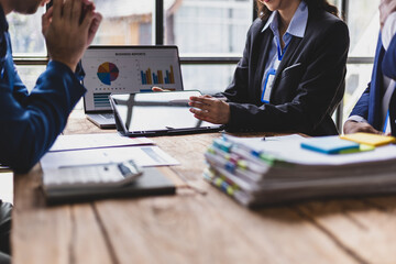 Business people analyzing financial data on digital tablet and laptop. Business team analyzing financial data on digital device in office, discussing strategy for growth and success.