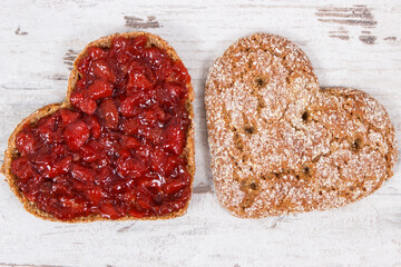 Slice of bread with strawberry jam for breakfast. Shape of heart. Rustic background