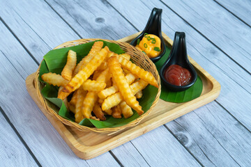 French fries with ketchup on wooden background.