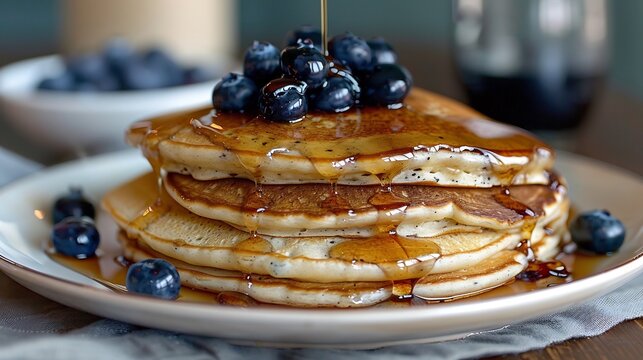 Fluffy pancakes with maple syrup cascade and blueberries white plate brunch food photography