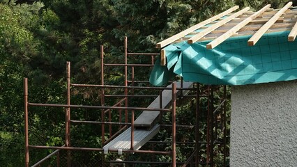 Remont dachu w domu jednorodzinnym z widocznym rusztowaniem przy elewacji