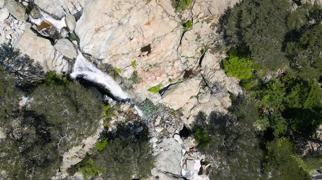 Aerial view of water cascading over the Cascade des Anglais, a waterfall on the L'Agnone river that flows through the forest and mountains of the GR20 trail at Vizzavona on the Mediterranean island of