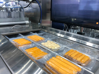 Machines are wrapping processed fresh food products meatball sausages . food production lines on conveyor belts, food production industry