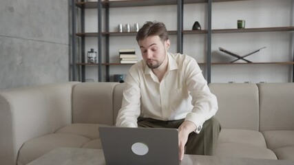 Surprised Man Reacting To Unexpected News On Laptop While Sitting On Sofa