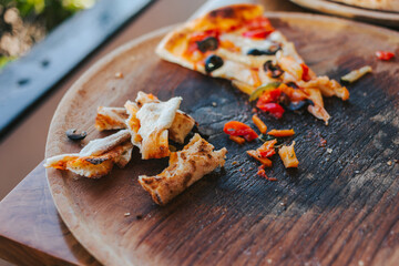 Slices of crispy pizza crusts on a wooden board