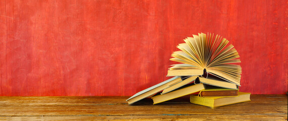 Heap of multicolored books on red grungy background, education,knowledge is power,reading...