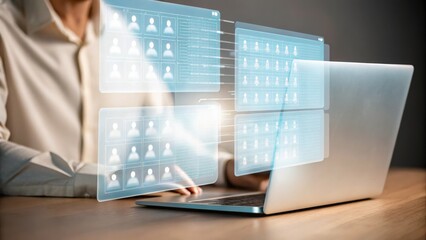 A person works on a laptop with futuristic digital interface screens displaying user profiles and data analytics.