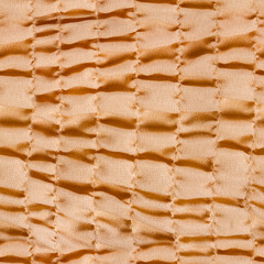 Seamless 4k photo texture of ivory or peach colored polyester frill cloth material.