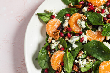 Fresh spinach and citrus salad with pomegranate and blue cheese for healthy eating