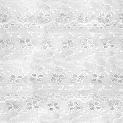 Seamless 4k photo texture of white colored cotton cloth with thread sewn ornament.