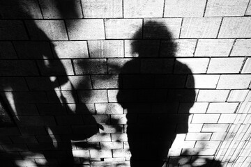 Silhouette shadow of women walking  city sidewalk in black and white high contrast