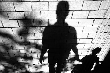 Silhouette shadow of people walking  city street sidewalk in black and white high contrast