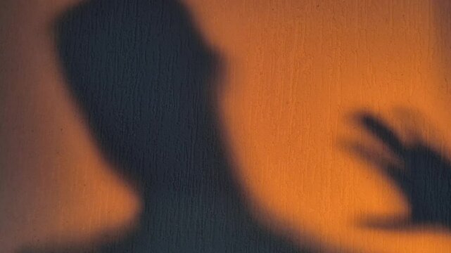 The shadow of the monster's hand reaching for the boy's head, close-up