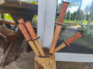 A wooden vase with four wooden sticks in it. The sticks are arranged in a way that they look like...