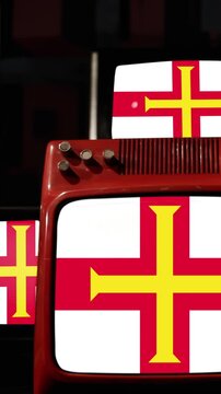 Stacked Old Televisions Showing Flag of Guernsey - Vertical 4K