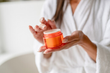 Closeup shot of unrecognizable female using moisturizing cream for hands at home, young woman...