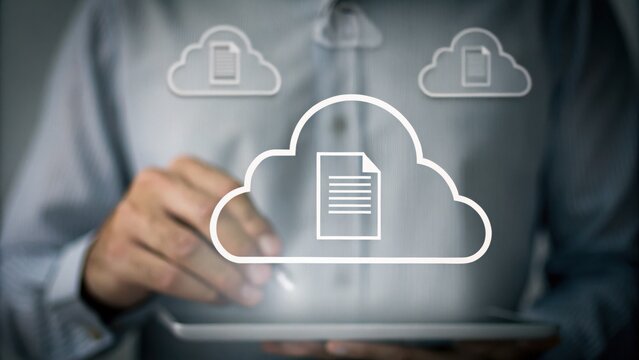 A person uses a tablet with digital cloud storage icons, representing cloud computing and document management.
