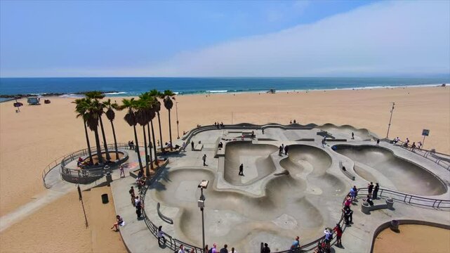 Personas disfrutando en un skate park en la playa.
