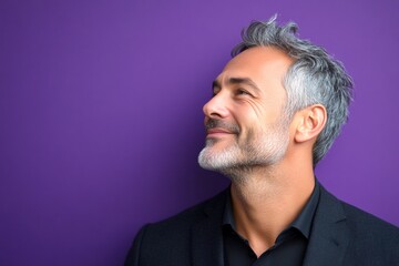 Fototapeta premium Modish men's slick back with fade haircut - midlife white man with grey hair. Purple solid background. Layout graphic design of style for aging men. A relaxed and poised man showing grace.