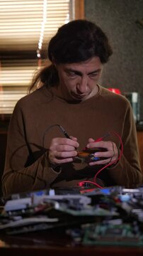 A deep and technical mood is captured by a close-up of computer circuit boards and components in the foreground, with a blurred technician actively working on them in the background