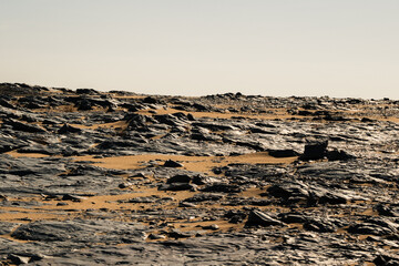 Ash-covered hills in Egypt's Black Desert under a clear sky, scenic and remote landscape. Volcanic	
