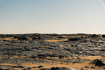 Ash-covered hills in Egypt's Black Desert under a clear sky, scenic and remote landscape. Volcanic	