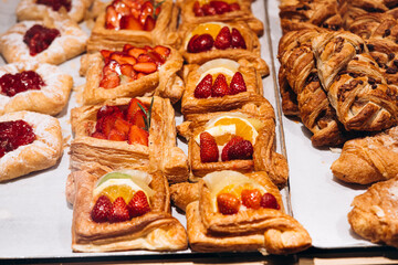 Display window of a pastry shop featuring summer fruit desserts with strawberries.