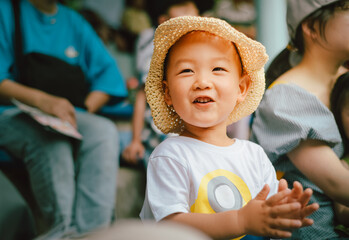 A 3-year-old child claps and laughs happily while watching a show at Ningbo Zoo