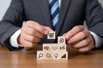Businessman Arranging Wooden Blocks with Target Goal Icons