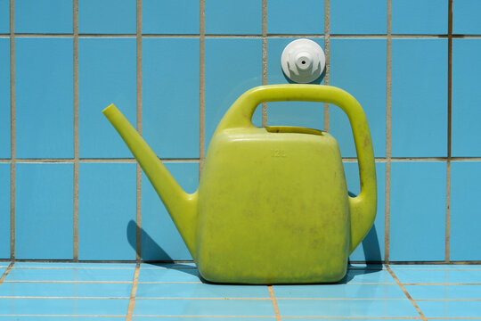 Leere Giesskanne steht in einem leeren Pool als Symbol f&uuml;r den Wassermangel