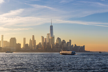 Ferry boat crossing the Hudson River at sunrise with the Financial District, including One World Trade Center, in view.