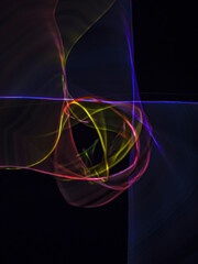 colorful light trails in dark background. Abstract light routes that rotate in vibrant colors....