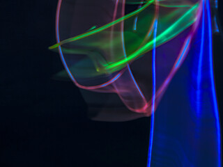 colorful light trails in dark background. Abstract light routes that rotate in vibrant colors....