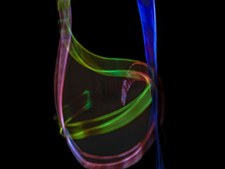 colorful light trails in dark background. Abstract light routes that rotate in vibrant colors....