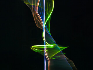 colorful light trails in dark background. Abstract light routes that rotate in vibrant colors....