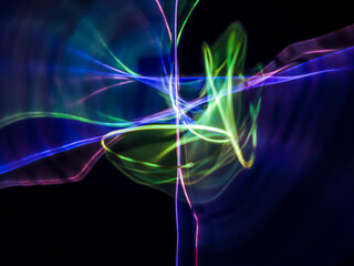 colorful light trails in dark background. Abstract light routes that rotate in vibrant colors....