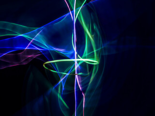 colorful light trails in dark background. Abstract light routes that rotate in vibrant colors....