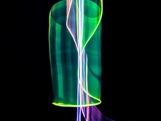 colorful light trails in dark background. Abstract light routes that rotate in vibrant colors....