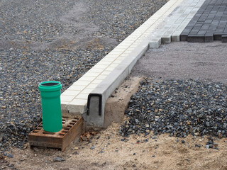 Straßenausbau - Bordstein und Rinnstein - Schacht für Abwasser am Straßenrand