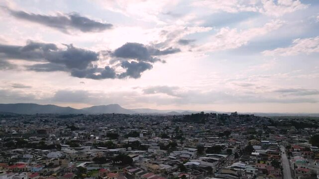 Timelapse de atardecer dorado sobre el norte de Guayaquil, Ecuador, con nubes en movimiento y luces urbanas encendi&eacute;ndose
