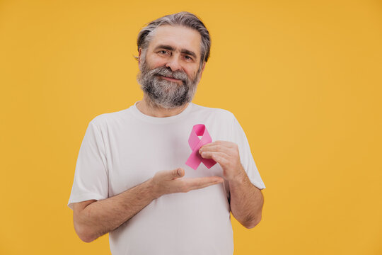 Senior man showing pink ribbon supporting breast cancer awareness