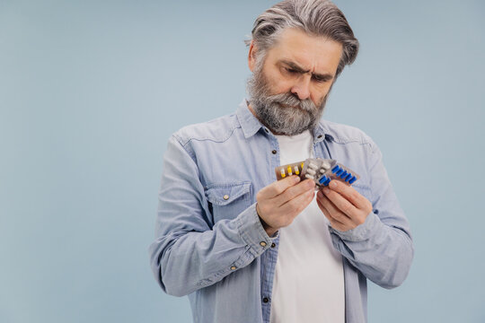 Confused Senior Man Choosing Right Medicine Pills Blister Pack