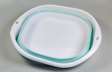 Folded rectangular household folding basin on a gray background