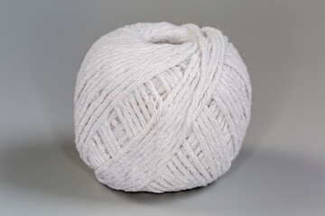 Coil of white cooking twine on gray background, front view