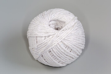 Coil of white cooking twine on a gray background