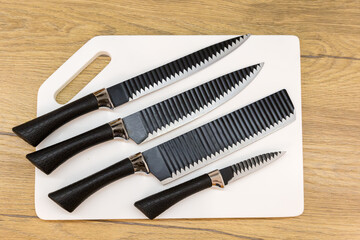 Set of the kitchen knives on cutting board, top view