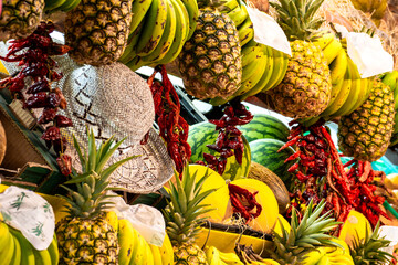Colorful market life with exotic fruits and regional products and straw hat