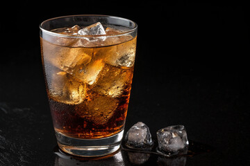 A cold Coke on a black background. Ice. Non-alcoholic drinks. Craft cola. Luxury. 
