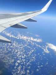 Aerial view from airplane window over the Mediterranean coast with wing in frame