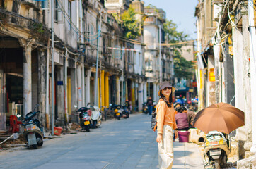 An Asian woman experiencing the blend of Minnan arcade architecture and modern lifestyle on...